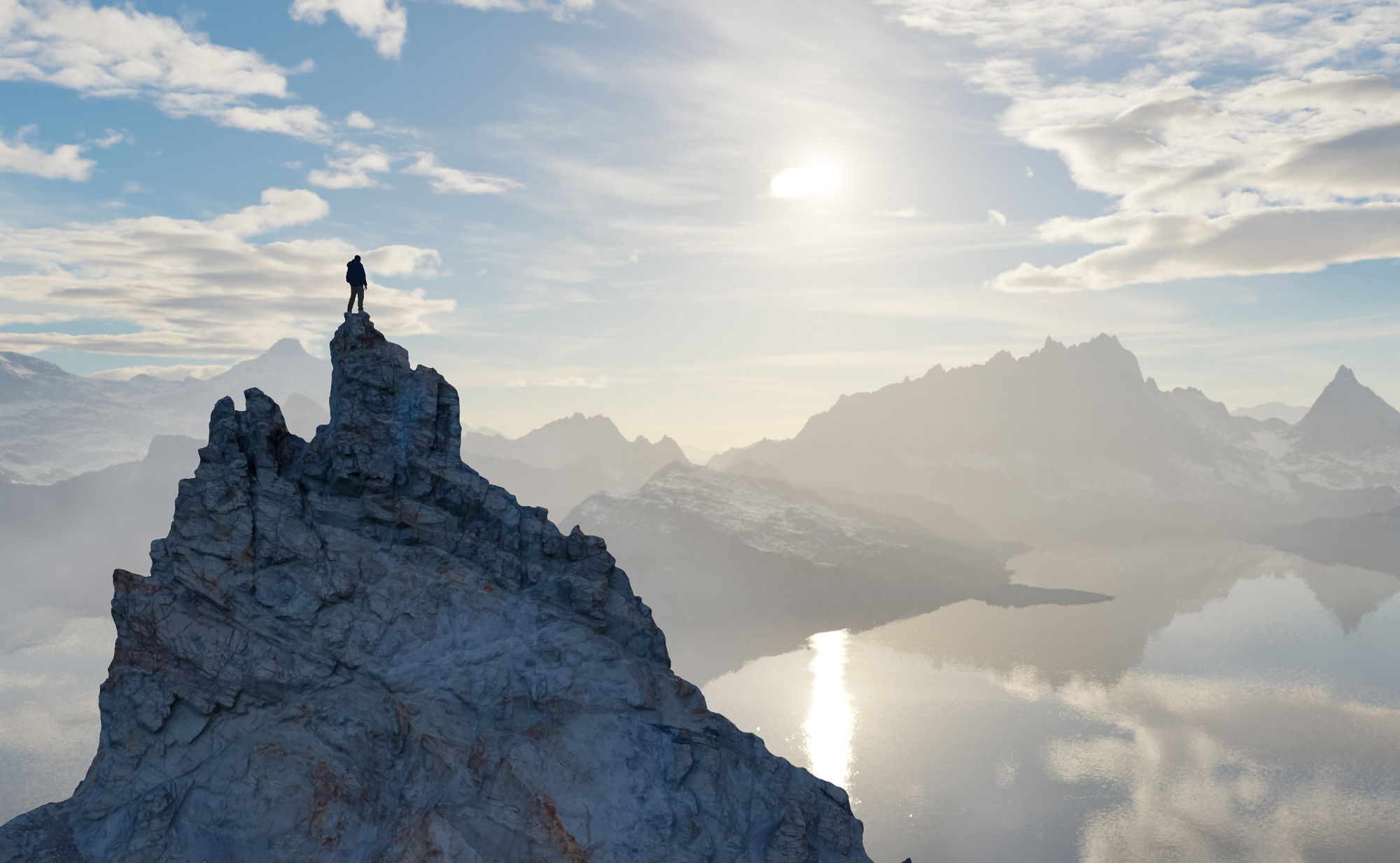 Ein Mensch steht auf dem Gipfel eines Berges, er blickt über eine nebelverhangene Berglandschaft mit einem See in der Ferne. Ein Symbolfoto von LIFE LIGHT für Mumijo, das in den Bergen Zentralasiens gewonnen wird.